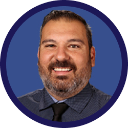 man with facial hair and a gray button up shirt